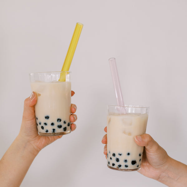 Reusable bubble tea boba glass straws in yellow and pink.