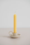An 6 inch natural tube beeswax candlesticks made with pure Canadian beeswax in a teacup candle holder.
