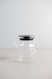 KINTO Cast glass teapot with stainless steel lid side view.