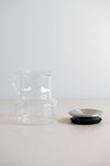 KINTO Cast glass teapot with stainless steel lid off the pot from the side view.