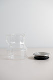 KINTO Cast glass teapot with stainless steel lid off the pot from the side view.