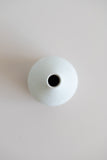 Ceramic bud vase with narrow mouth in white with natural specs from the over view.
