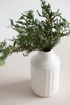 Ceramic peel-carved vase handmade in Canada and finished in a satin white glaze with an evergreen pine arrangement.