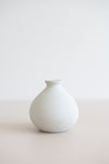Ceramic round bud vase in white with natural specs from the side view.
