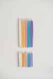 Rainbow of pastel gala candles above birthday candles.
