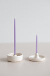 Purple beeswax gala and birthday candles in a ceramic handmade candle holders.